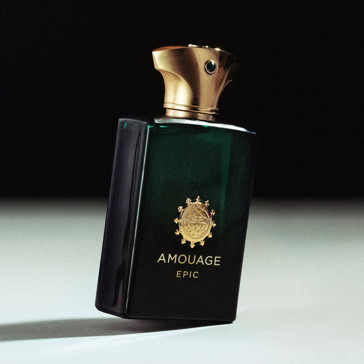 Amouage Epic perfume bottle with gold cap on a dark background