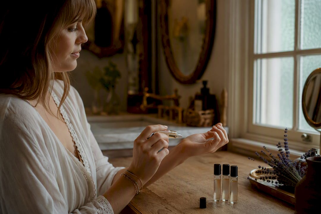 Hand applying powdery perfume sample on wrist
