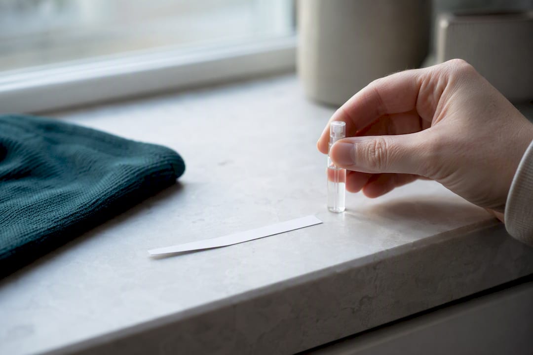 Anonymous decant beside a fragrance blotter