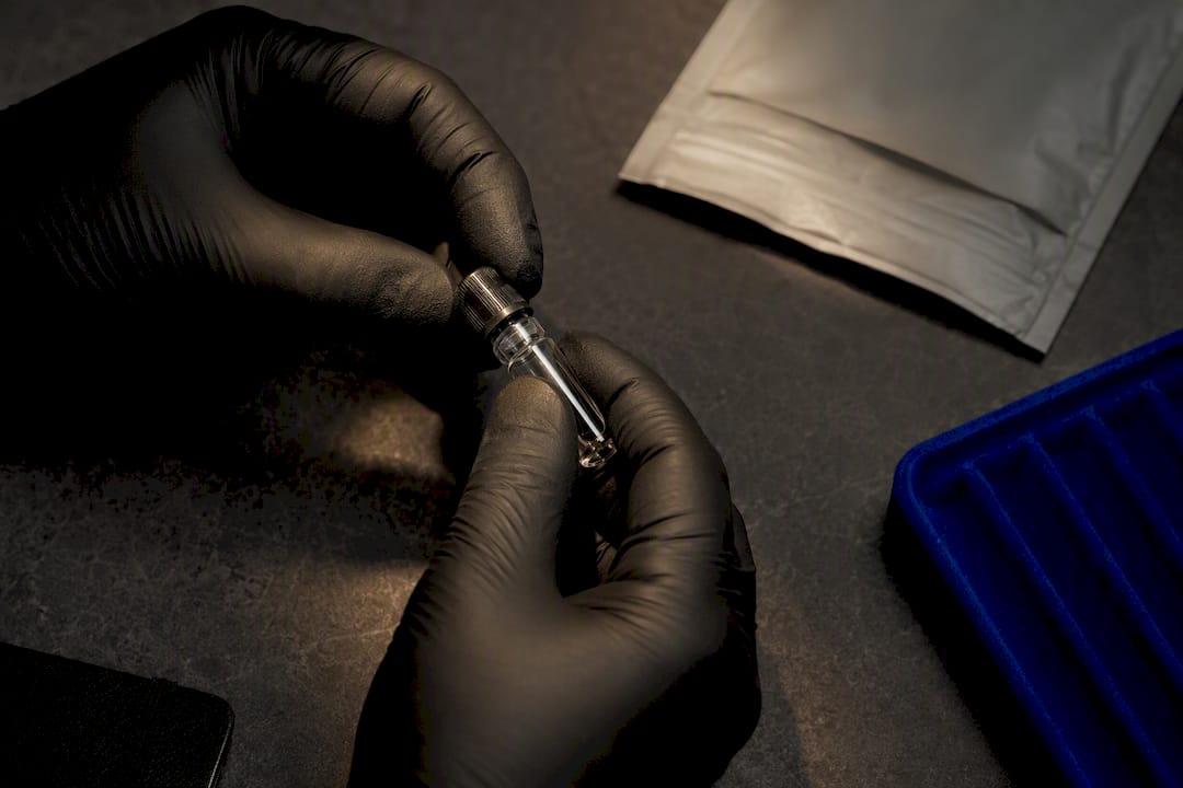 Hands inspecting an anonymous fragrance vial seal