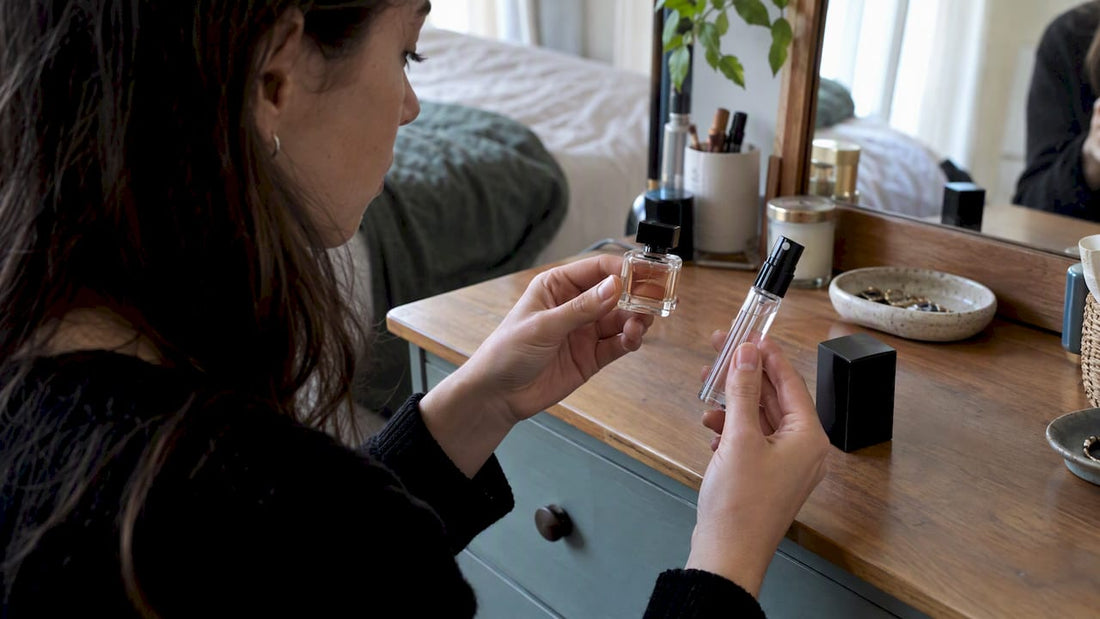 Hands comparing a perfume mini and decant