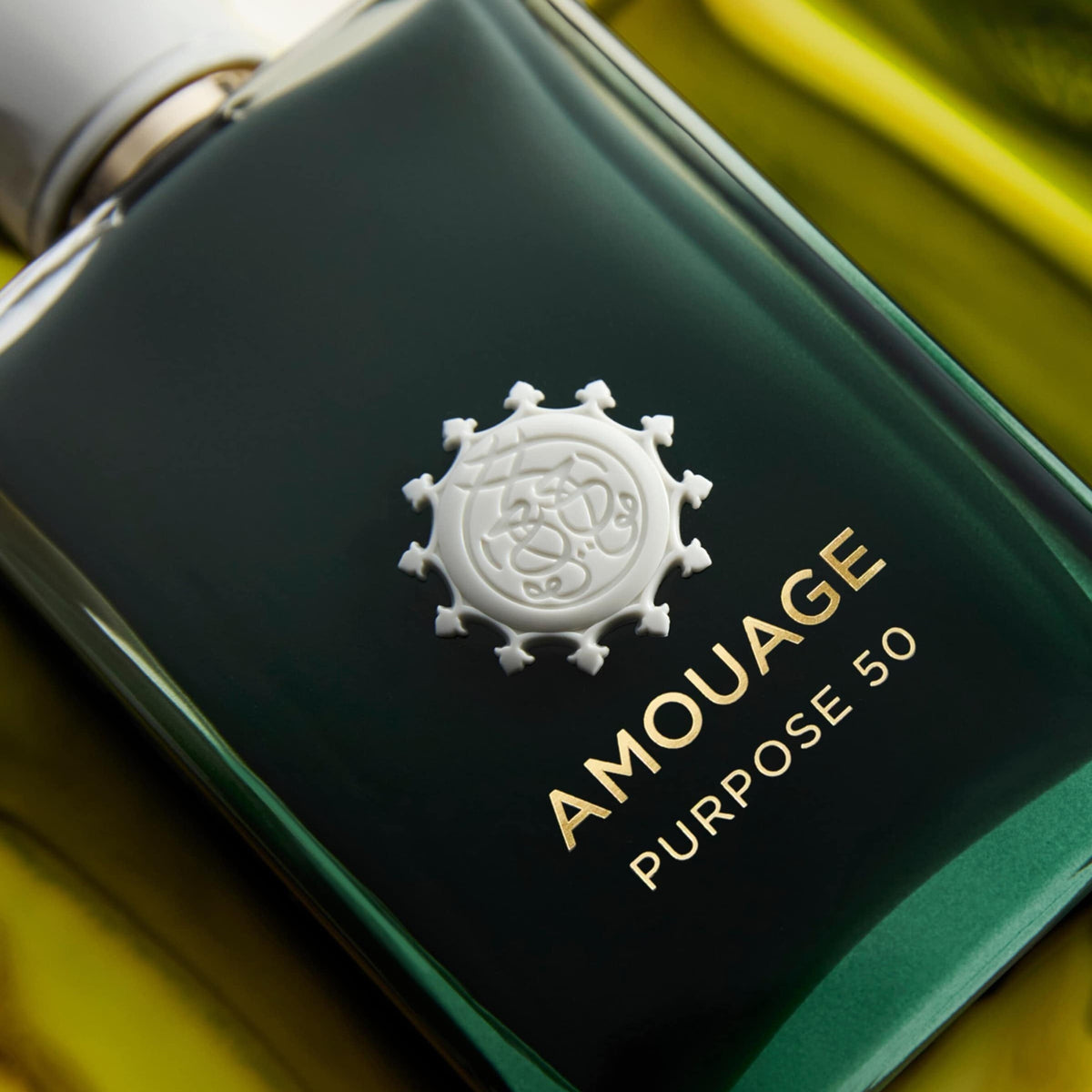 Amouage perfume bottle with green cap on a blurred background