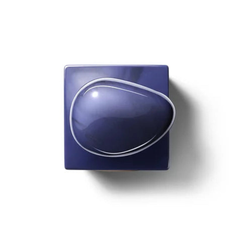 A glossy dark blue ceramic dish with a teardrop-shaped recessed center, photographed from directly above on a white background. Armani Privé Indigo Tanzanite Eau de Parfum