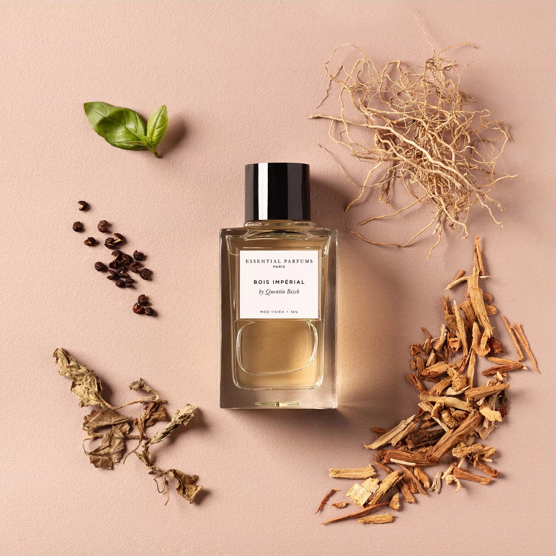 Perfume bottle with botanical elements on a beige background