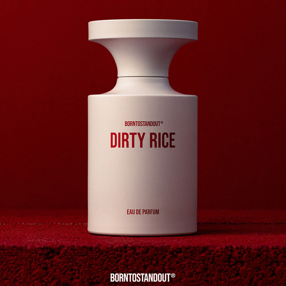 White perfume bottle labeled 'DIRTY RICE' on a red background with text 'Rebel Against Standards'.
