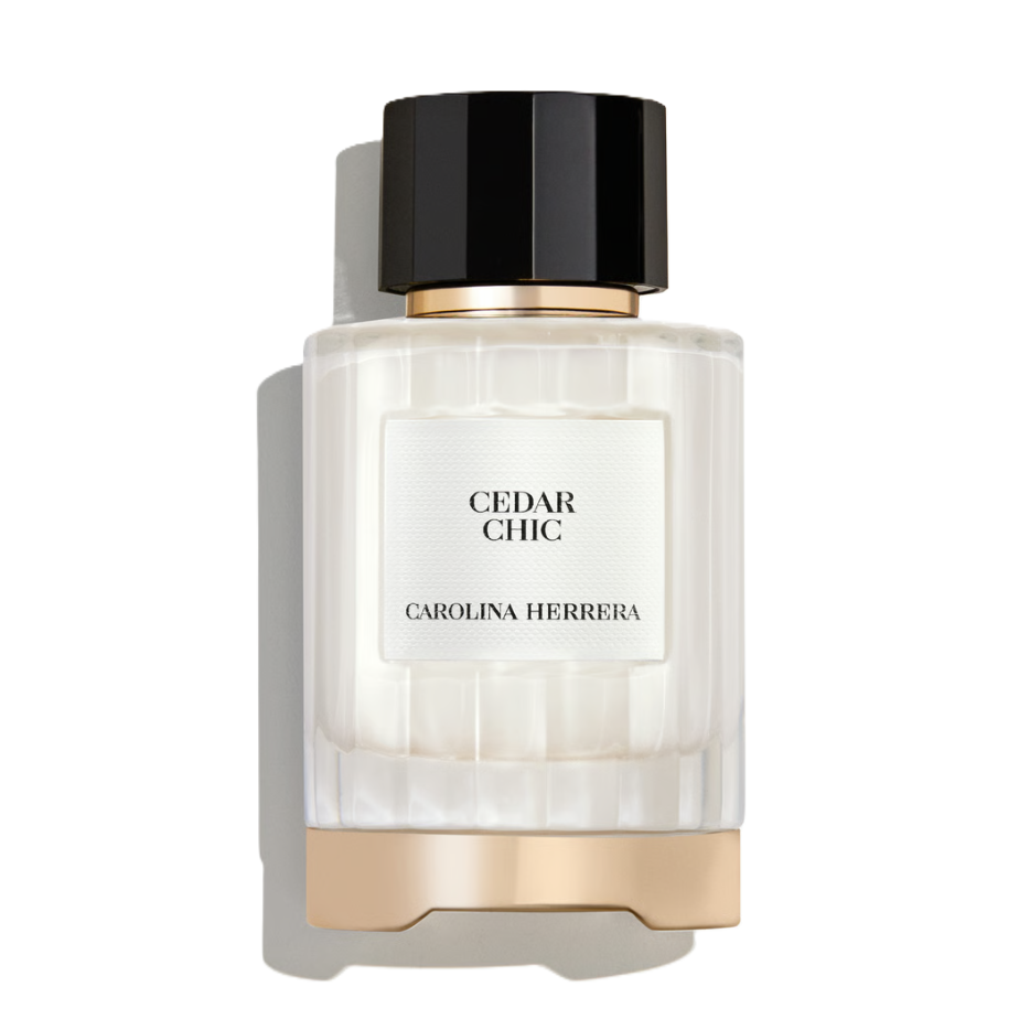 Carolina Herrera Cedar Chic perfume bottle with a ribbed clear glass body, white label, black cap, and gold metallic accents, shown on a white background with a soft shadow.