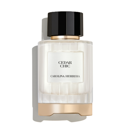 Carolina Herrera Cedar Chic perfume bottle with a ribbed clear glass body, white label, black cap, and gold metallic accents, shown on a white background with a soft shadow.