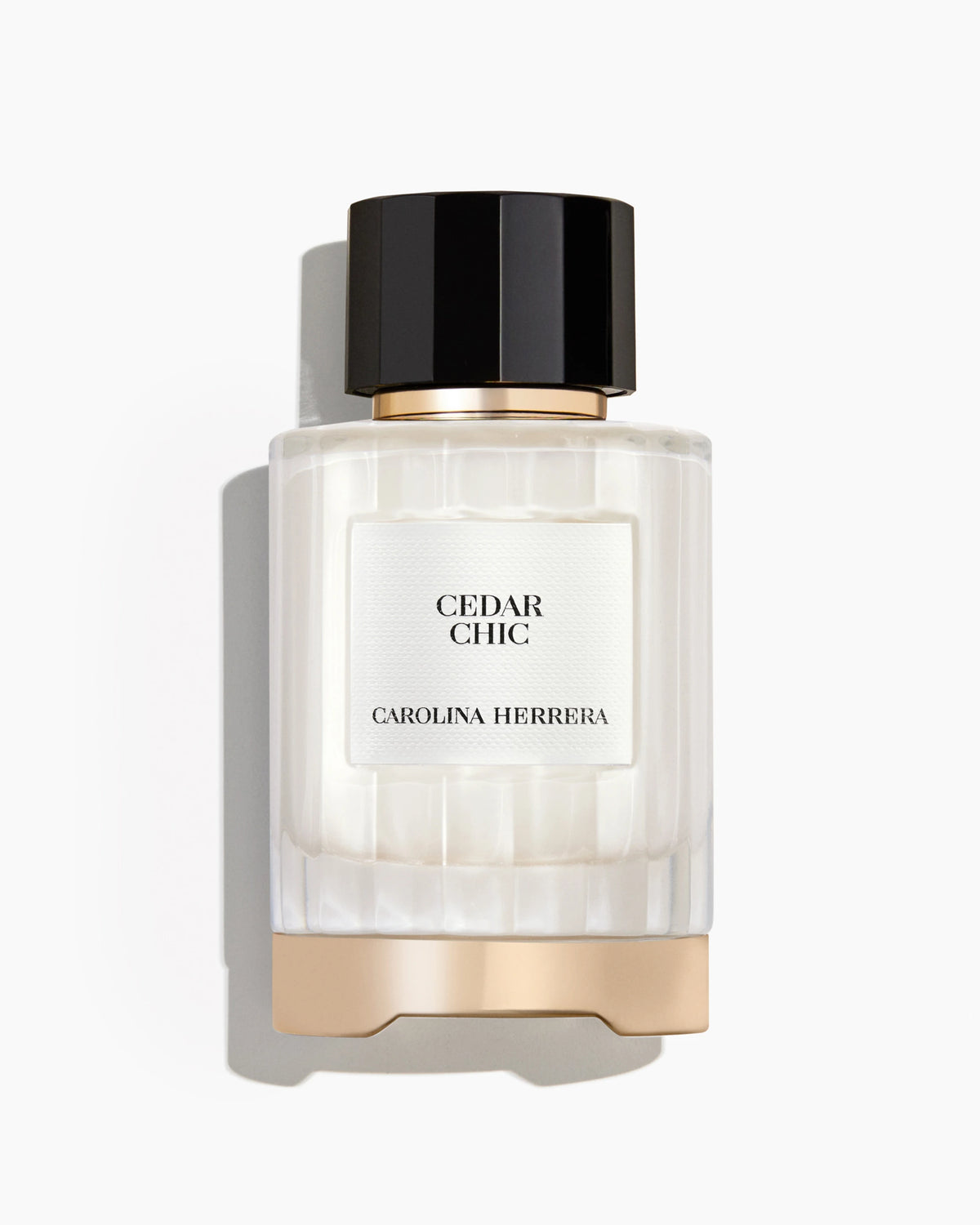 Perfume bottle labeled 'Cedar Chic' by Carolina Herrera on a white background