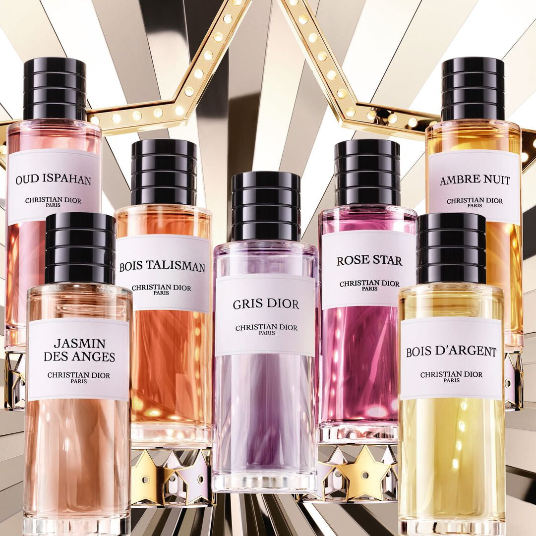 Collection of perfume bottles with black caps on a reflective surface