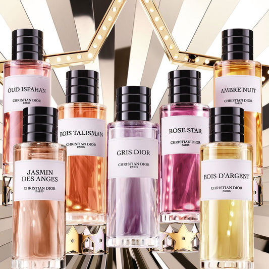 Collection of perfume bottles with black caps on a reflective surface