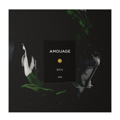 A square product card or packaging insert reading 'AMOUAGE EPIC MAN' with a small yellow sun icon, centered on a dark abstract background with green and gray flowing shapes.