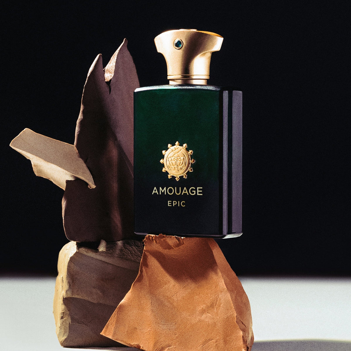 Amouage Epic perfume bottle on a wooden stand with a dark background