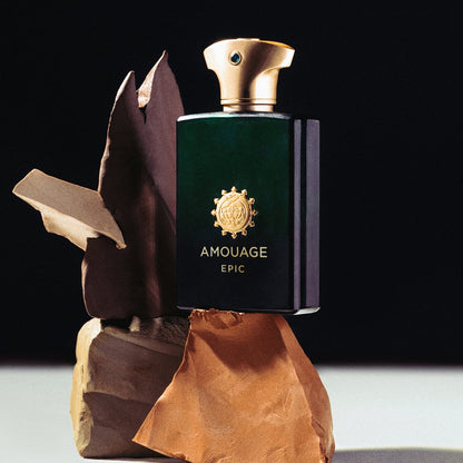 Amouage Epic perfume bottle on a wooden stand with a dark background