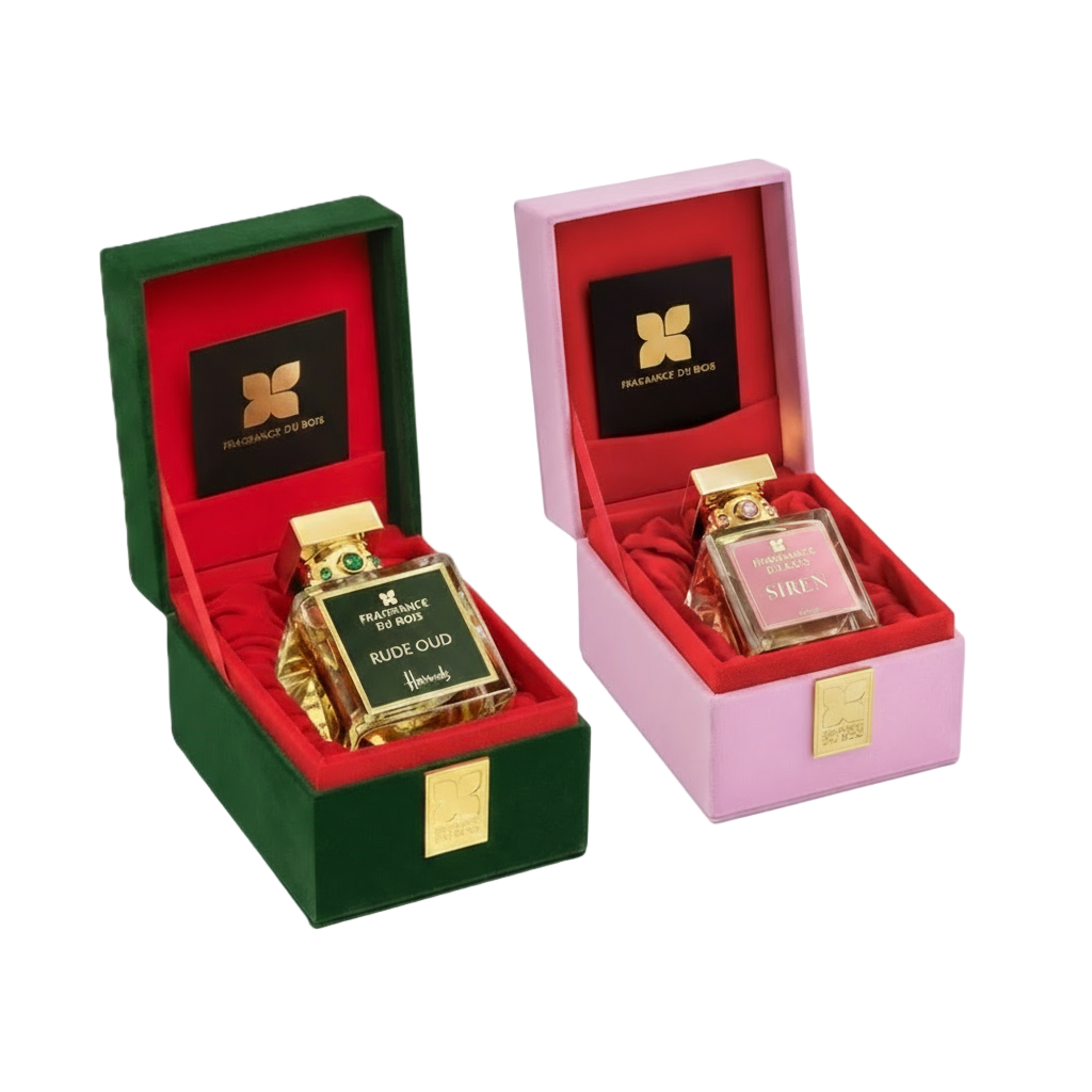 Two gold perfume bottles in open red and pink boxes with promotional text on a white background.