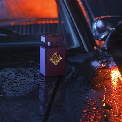 Purple perfume bottle on a car dashboard with red interior lights