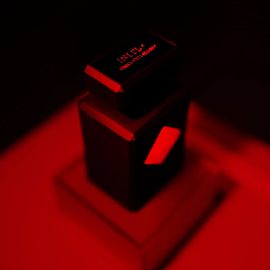 A dark, moody studio shot of a black rectangular product box or container with a smaller matching box on top, illuminated by dramatic red lighting against a black background.