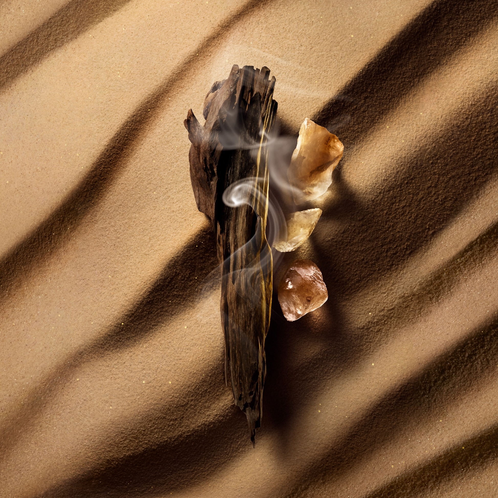 Incense sticks with smoke on a sandy surface