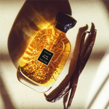 Perfume bottle with a vanilla bean on a light background