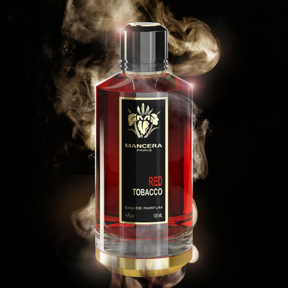 Mancera Paris Red Tobacco Eau de Parfum in a clear rectangular glass bottle with a black cap and black label, shown against a black background with dramatic smoke effects and gold branding.