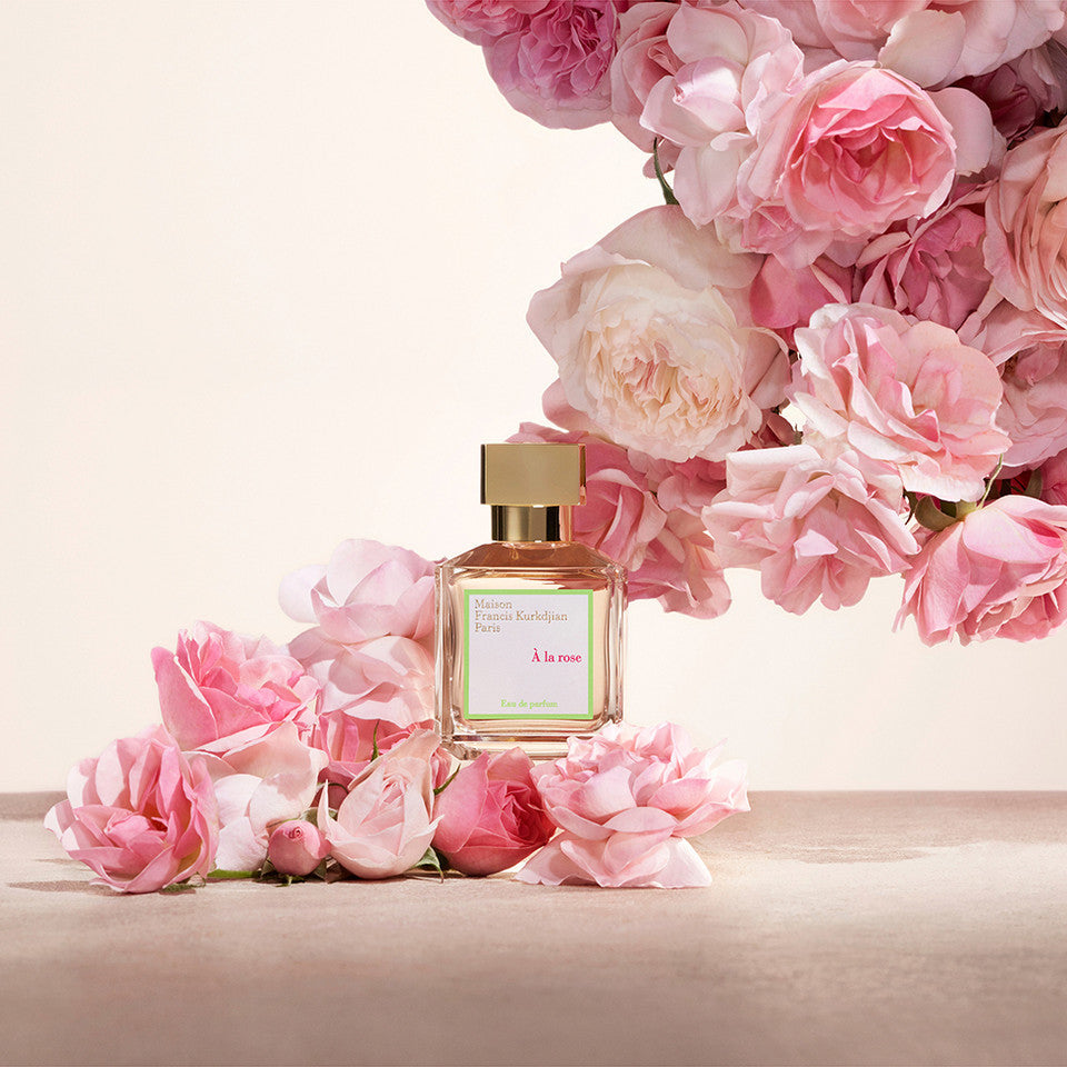 Perfume bottle with pink flowers on a light background