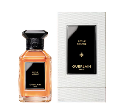 Guerlain Pèche Mirage Eau de Toilette bottle with amber liquid and a black cap, shown next to its white textured packaging box with a black label.