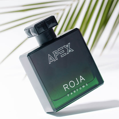 Roja Parfums Apex perfume bottle with palm leaves in the background