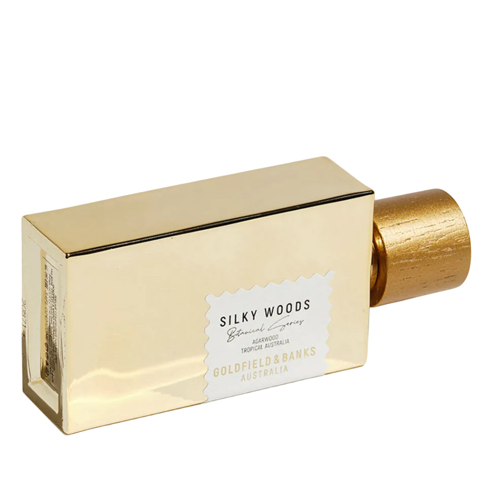 Gold perfume bottle with a white label on a white background