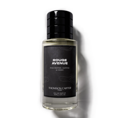 A bottle of Thomsom Carter Rouge Avenue Eau de Parfum, featuring a black cap and a black label with white text, set against a clean white background with a soft shadow.