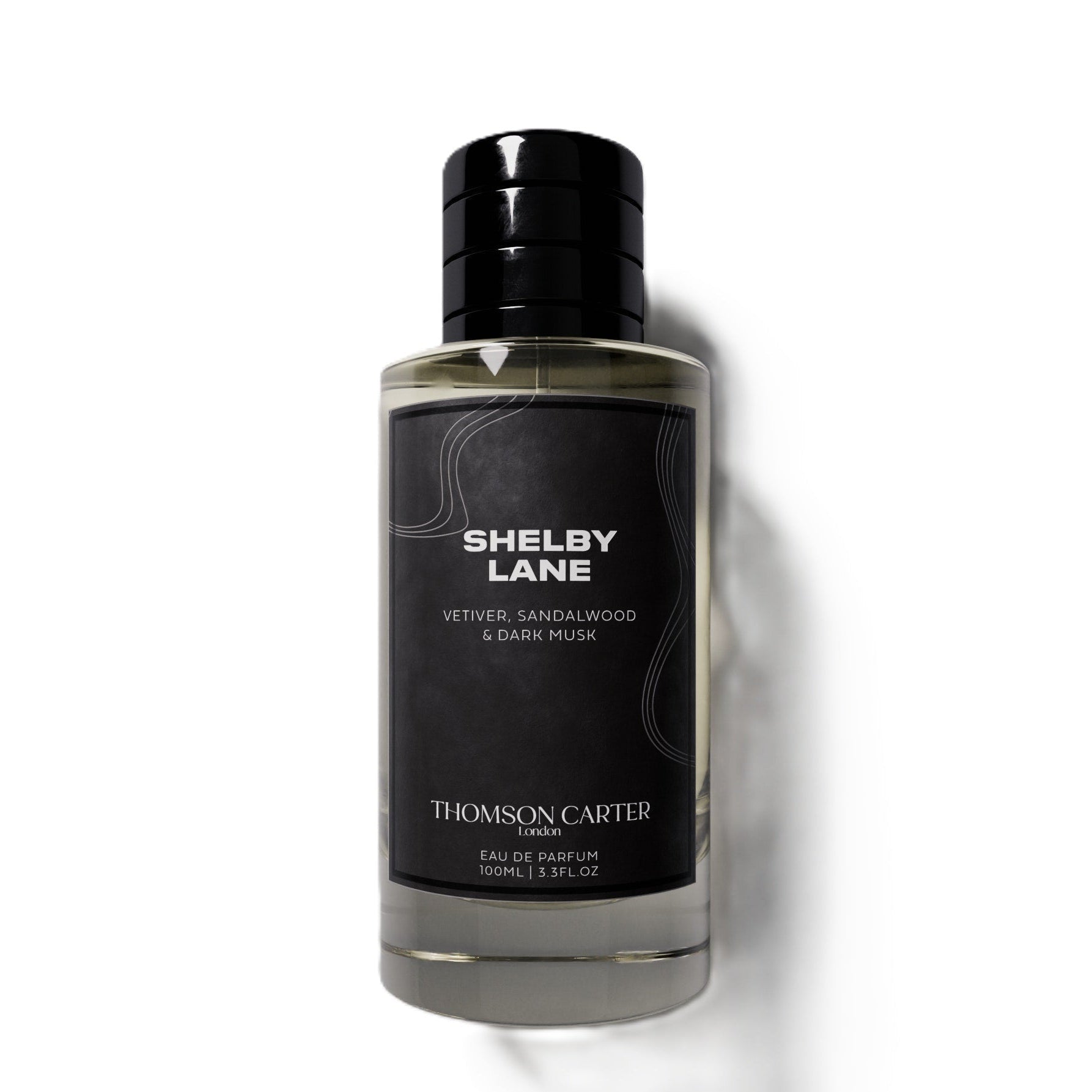 Thomson Carter Shelby Lane Eau de Parfum in a clear glass bottle with a black cap and black label, set against a plain white background with a soft shadow.