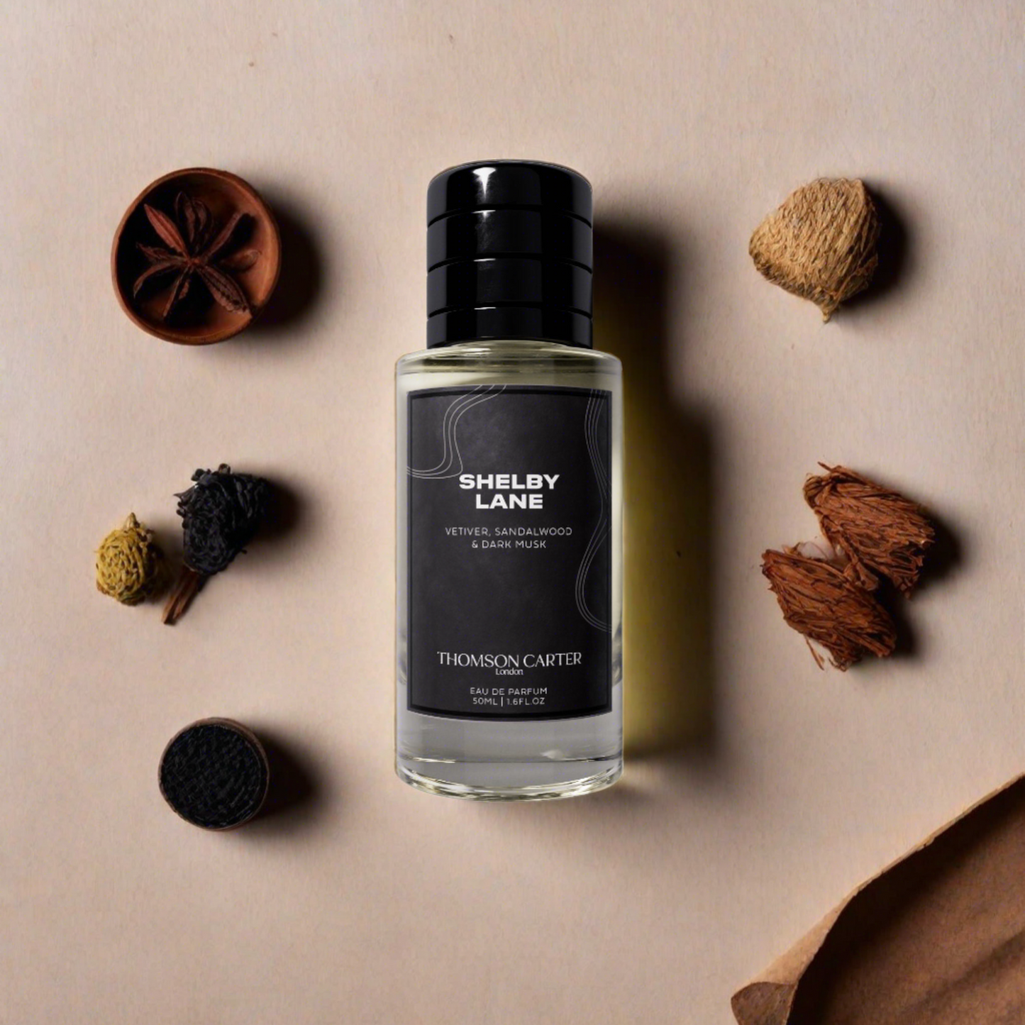 Shelby Lane perfume bottle surrounded by dried herbs on a beige background